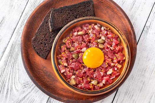 Portion of Beef steak tartare topped with a raw egg yolk