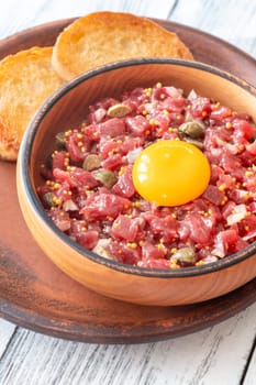 Portion of Beef steak tartare topped with a raw egg yolk
