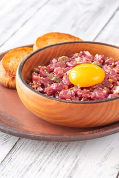 Portion of Beef steak tartare topped with a raw egg yolk