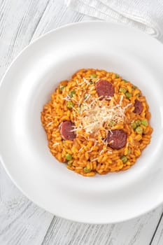 Portion of risotto with chorizo sausage and green peas