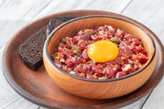 Portion of Beef steak tartare topped with a raw egg yolk