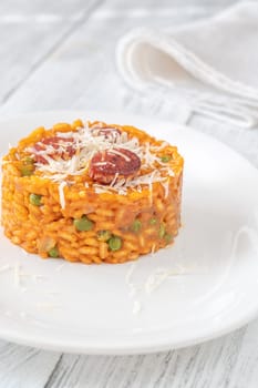 Portion of risotto with chorizo sausage and green peas