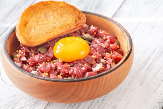 Portion of Beef steak tartare topped with a raw egg yolk