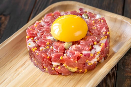 Portion of Beef steak tartare topped with a raw egg yolk