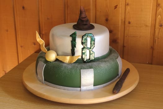 A round chocolate cake with embellishments and an inscription