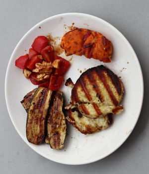 Several pieces of grilled meat arranged on a plate
