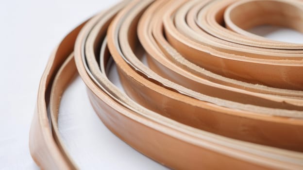 This close-up shot showcases a roll of rich brown leather, highlighting its intricate texture and deep color. The leather roll is tightly wound, with visible grains and creases adding to its rugged appeal.