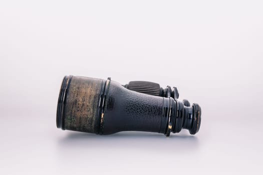 Antique oxidized binoculars from last century, with signs of time, isolated on white, rusted optics, reflecting a romanticized view of discovery and exploration