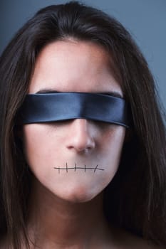 Eerie portrait, blindfolded woman, no mouth, silenced. Free speech, expression denied in dictatorships, totalitarianism. Democracy represents dialogue, utmost liberty for everyone