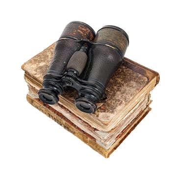 Stacks of very old paper books with weathered yellowed leather covers, scratched and ruined, mysterious and full of secrets surmounted by binoculars of an obsolete shape in a concept of fantastic jour