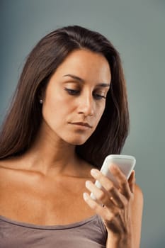 Serious, upset woman observing cellphone screen. On verge of anger, restraining fury. Bad news, incoming problems. Possible phone malfunction