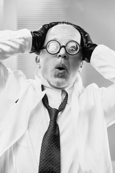 Black-and-white movie villain: a mad professor, a wicked scientist with exaggerated expressions. Believes he's superior, uses humanity as tools for his evil plot involving a global conspiracy to inser