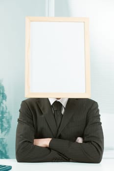 Cartel head. White collar with a white sign for your COPYSPACE instead of a head. Sitting at desk in formal dress with arms folded, conveys determination and strength.