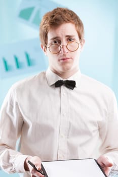 A somewhat nerdy, slightly subservient young man in a dated office suit, clutching a notepad, gazes sadly. His white shirt and bowtie suggest he may be an accountant