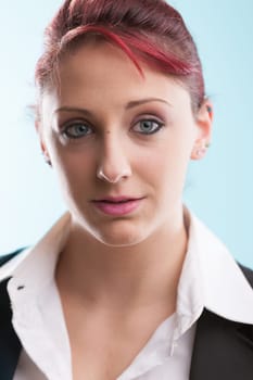 Young redhead in a formal suit and open white blouse contemplates her office tasks against a backdrop of her workplace. With blue eyes, she exudes confidence in job opportunities and in you, her soon-