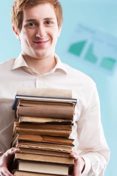 A young man offers a pile of antique books, with a blurred business backdrop. Knowledge builds on past information