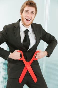 young businessman in a manga or anime attitude with a somewhat dumb and somewhat crazy, amused expression makes the gesture of cutting off his penis. Humorous depiction of self-sabotage.