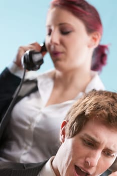 Busy office scene! Man and woman handling high-pressure calls. Training is critical in such roles