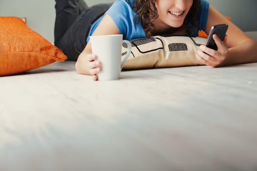 Resting at home among plush pillows, a curly-haired female delves deep into her phone's expansive world. She engages with social platforms, streams shows, explores dating apps, plays video games, and