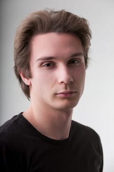 Against a neutral canvas, this attractive man's portrait shines. His black shirt complements short brown hair, but it's his intense look and smile that capture attention
