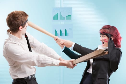 Employees using office furniture for a mock-battle. Business warriors or friendly fire in action?