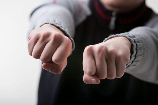 guessing game is depicted in the close-up of a young white-skinned man's hands. Wearing a gray and black sweater, he challenges you to guess which hand, if any, holds an object