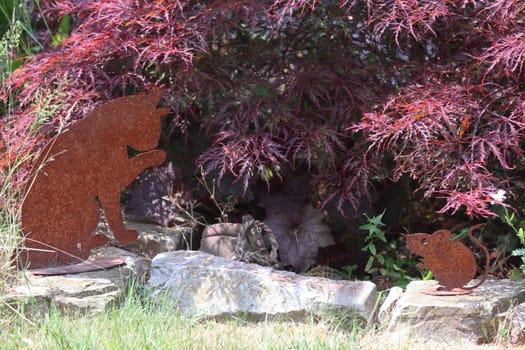 a cat made of rusted metal, placed as a decoration in the garden