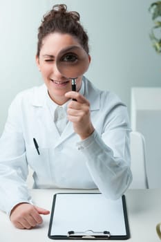 Magnifying her eye, a scientist jests. Despite dedication, her playful spirit endures. She suggests intensive academia can pair with joy, hoping young learners embrace this ethos