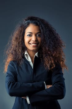 With mesmerizing curls, a 40-year-old black woman shines in contrasting attire. Navigating challenges related to race and gender, she doesn't just fit in she leads, making her journey remarkable