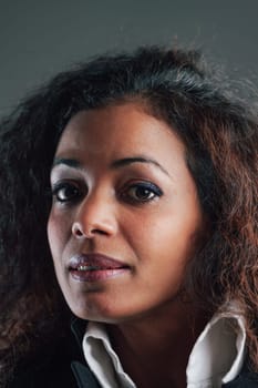Portrait of Black-skinned Woman with long wavy hair, in elegant white shirt and black jacket, expression questioning, doubtful, perhaps a little afraid but undoubtedly uncertain. What will happen to u