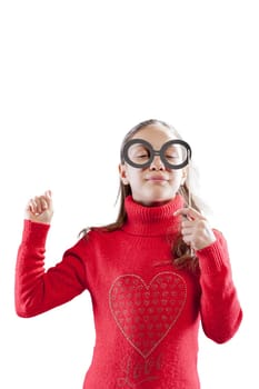 girl goofing around with cardboard disguises, making amusing faces to entertain others. Using faux glasses and moustaches, she's drawing attention and developing her social skills. Photographed agains