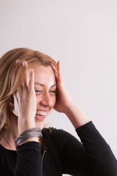 oyful close-up: a woman laughs, sweeping hair from her temples. The motion not just functional but perhaps underlining the hilarity of a comment. Pure positivity. Plenty of copyspace above