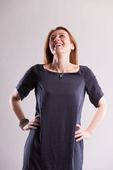 The epitome of self-confidence and serenity, a middle-aged blonde wears a gray-blue dress. As a skilled professional valuing independence, she's a beacon of inspiration for many women