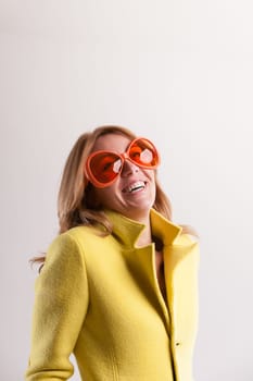 In her oversized glasses, a humorous woman encapsulates joy, unity, and the occasional spark of madness, reinforcing our vibrant humanity over machine-like existence