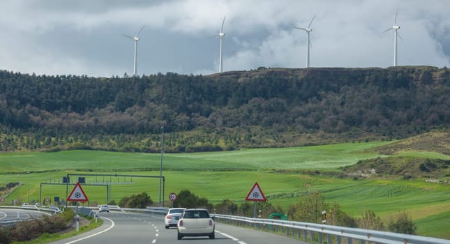 Wind turbines on the top of the hills. Landscape seen from freeway or autovia