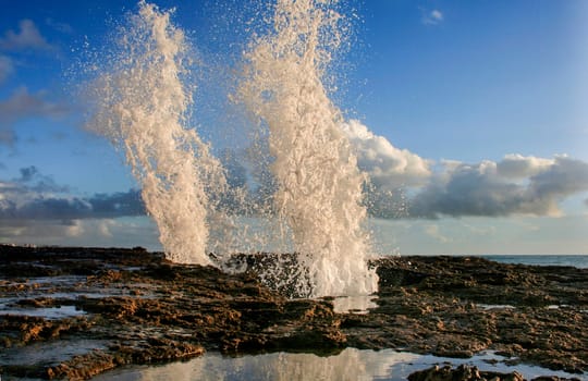 Blowholes at Cadiz city coastline sending burst of water high into the air, Spain
