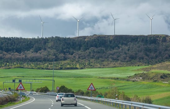 Wind turbines on the top of the hills. Landscape seen from freeway or autovia