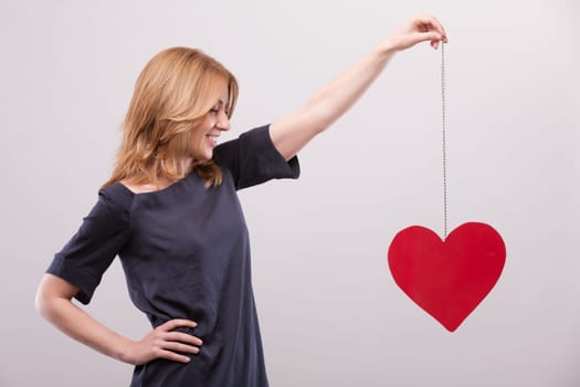 Elevating a symbolic heart, a woman conveys cardiovascular health's importance. Recognizing the role of diet, blood pressure, and vein upkeep, she understands that life's essence allows for romantic e