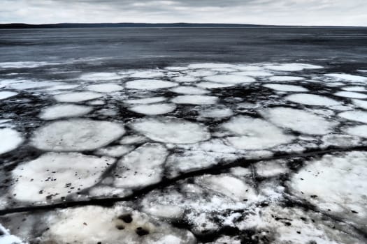 Ice drift in spring on Lake Onega, Karelia. Dangerous thin spring ice in April. Aggregate accumulations of fine-crystalline grains. Opening of small lakes, ponds and reservoirs. Crushed ice floes.