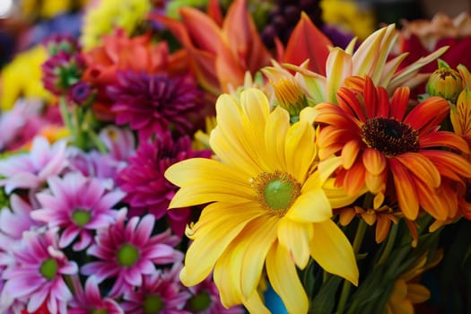 A colorful assortment of flowers arranged in a vase, creating a vibrant and visually appealing display.