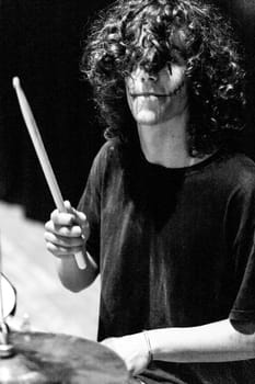 In a monochromatic capture, a drummer's spirit comes alive. Dark makeup, raw energy, and swift movements depict his passion for music's art and mechanics