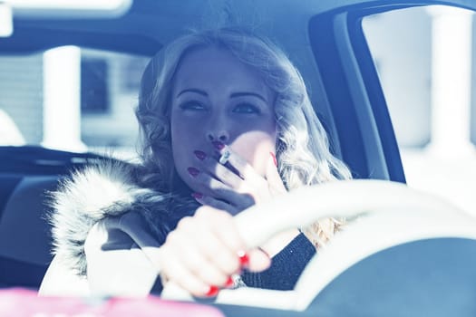 Blonde girl in a car is a tourist with long hair, smoking a cigarette to emulate a pop star while enjoying her European vacation. She loves solo travel, never knowing who she'll meet along the way, ce
