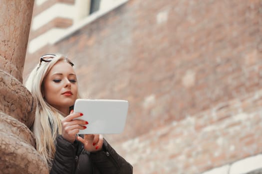 blonde tourist, lacking preparation for her European adventure, finds her way using a tablet. She relies on internet resources for maps and guides, feeling less uninformed and enjoying her travels