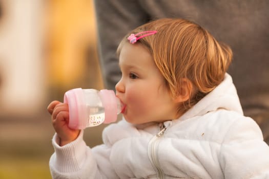 With a gentle grasp, the young one quenches her thirst, peaceful and serene