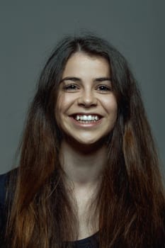 Cheerful woman's portrait exudes strength. With lengthy hair and an animated smile, her gaze holds the future. Her hair reaches mid-body, and her presence sparks joy