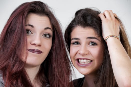 These two women, dressed up with precise makeup and long hair, dont hold back on fun. Making silly faces, they embody the perfect blend of elegance and whimsy