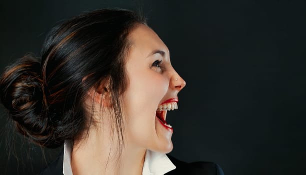 Profile of determined woman. Business champion or temporarily upset? Red lips, tied hair, white blouse, black outerwear. Space right
