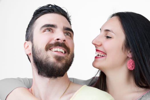 Loving couple, enjoying their time together. Black-haired woman with red lipstick and earrings and her bearded boyfriend, embrace and have fun isolated on white
