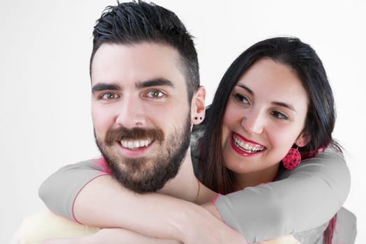 Fun and love blend as the couple, with her long black hair, red lipstick, and earrings, and his beard, embrace joyfully, isolated on a white background