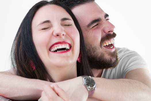 bearded man and his girlfriend with red lipstick, earrings, and long black hair, embrace and have fun, as though posing for holiday photos, on white